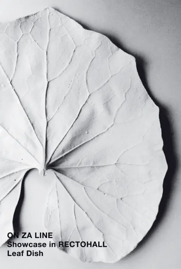 Monochrome photo of a white porcelain object shaped like a taro leaf.