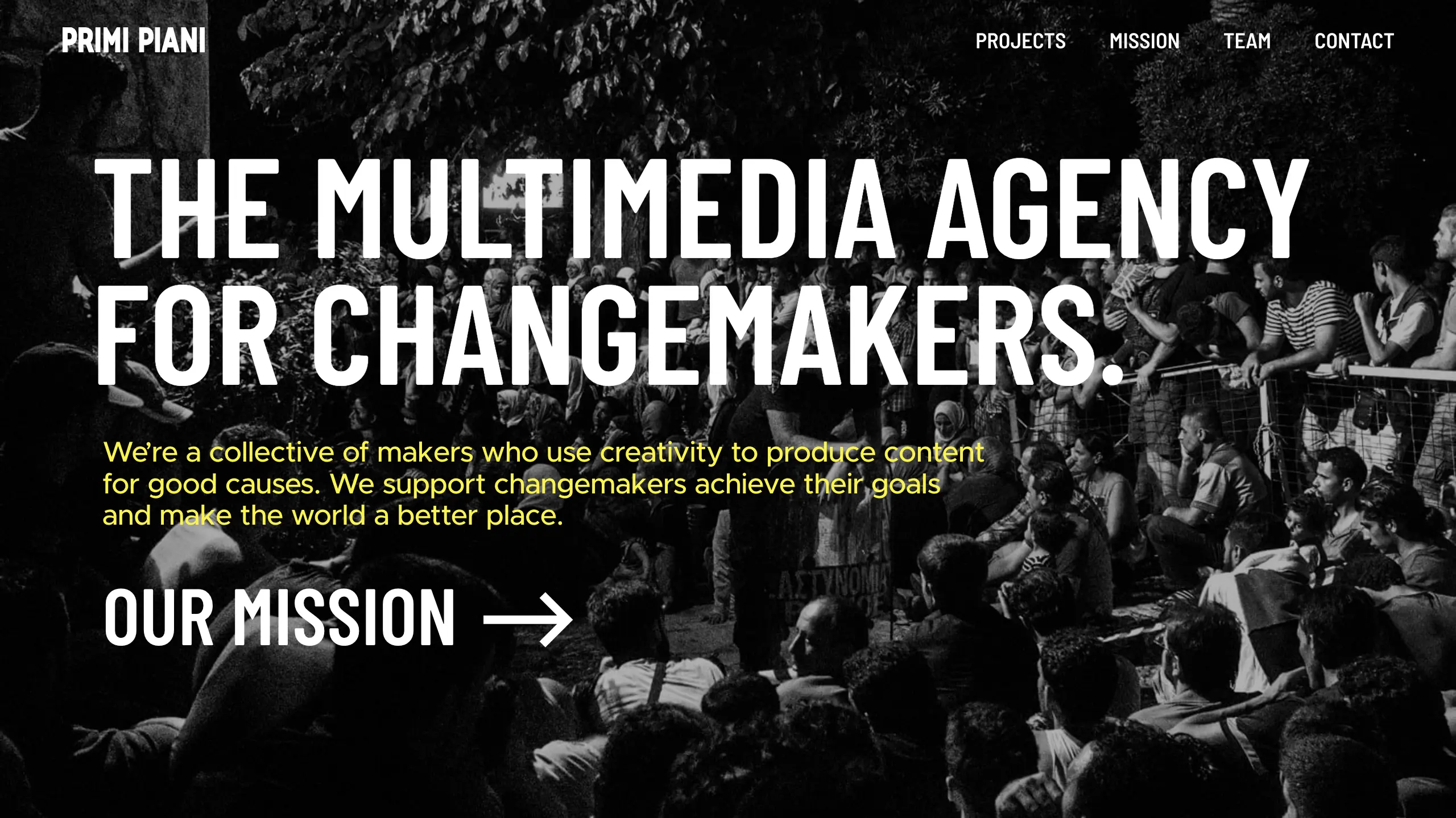 Top page image of the website, Primi piani. #The multimedia agency for changemakers." In the background, dozens of people are waiting for something in the darkness.